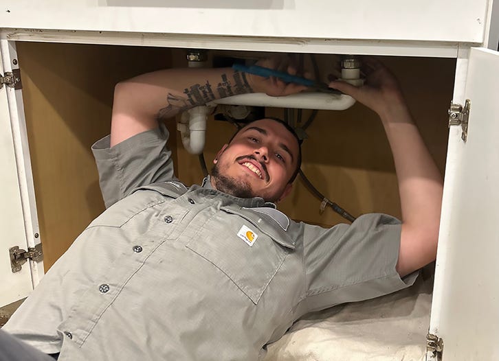 B&A Plumbing licensed plumber performing residential plumbing repair under kitchen sink in Schaumburg IL